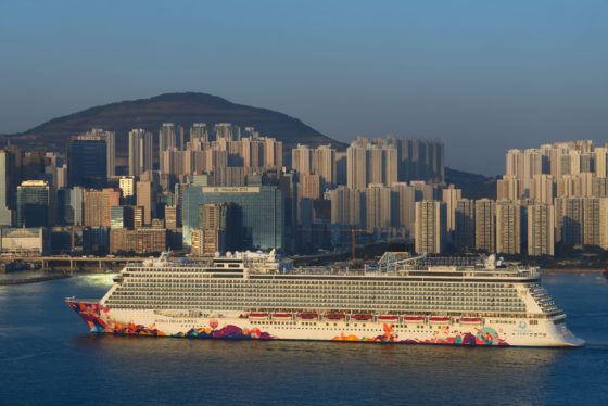 The World Dream cruise liner arriving at Kowloon Bay, Hong Kong, China as the sun goes down in the evening.